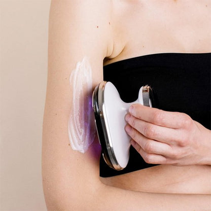 Appareil de massage glissé le long du bras d'une femme, soin du corps