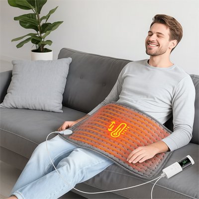 Coussin chauffant appliqué sur les cuisses d'une homme assis, moment de détente