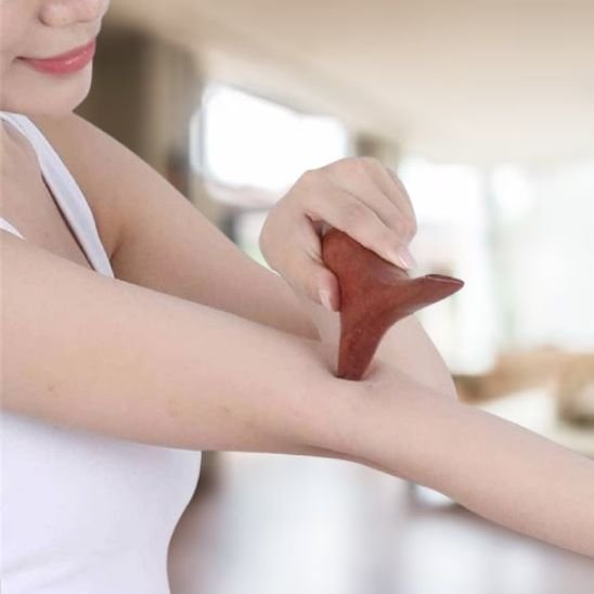Gua sha glissé le coude d'une femme, moment de relaxation