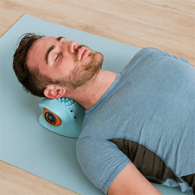 Masseur cervical placé sous la nuque d'un homme allongé, tête lumineuse rouge