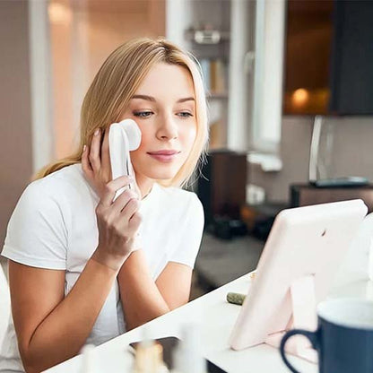 Masseur visage appliqué sur la joue d'une femme souriante pendant sa routine beauté