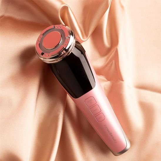 Masseur visage rose gold en gros plan, tête de l'appareil visible