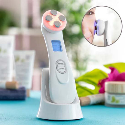Masseur visage rose posé sur un meuble, présenté avec ses accessoires