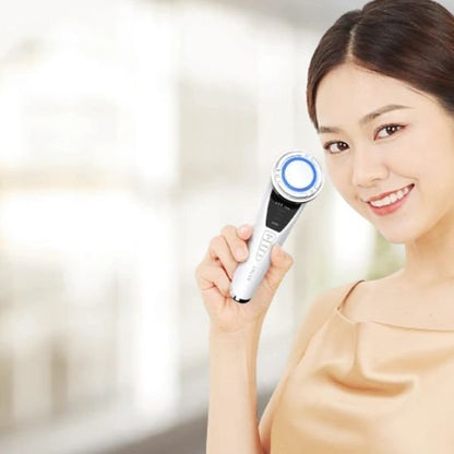 Masseur visage utilisé par une jeune femme souriante 