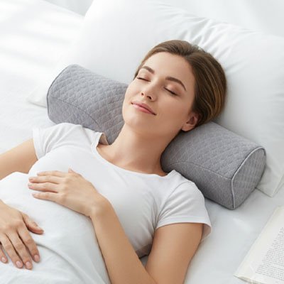 Oreiller cervical ergonomique utilisé au lit pour maintenir l’alignement naturel de la tête et du cou