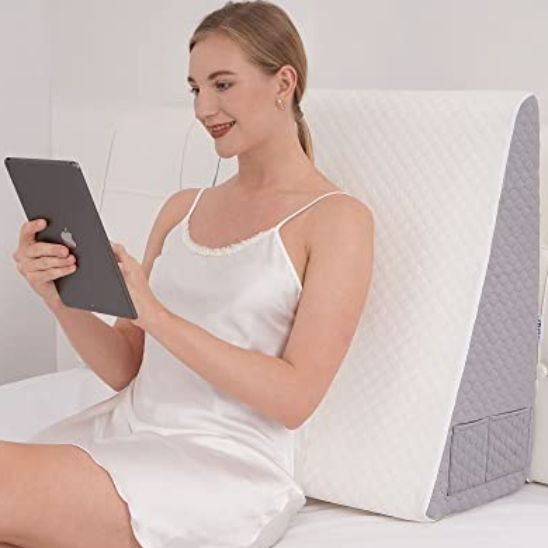 Oreiller ergonomique inclinable utilisé pour lire ou utiliser une tablette en position assise
