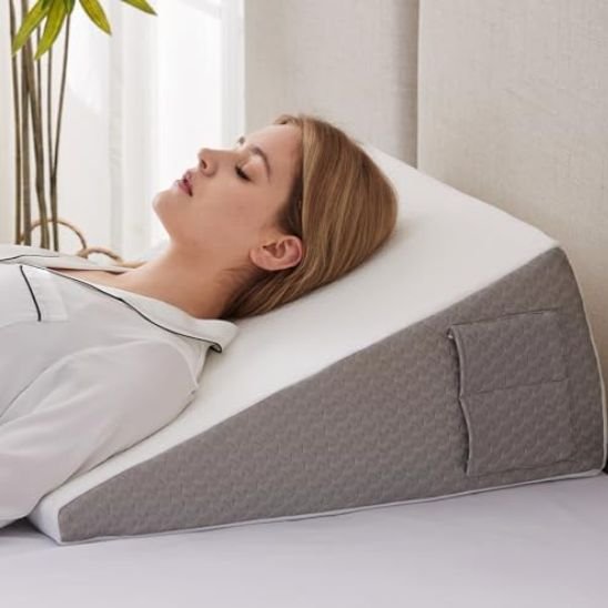 Oreiller ergonomique triangulaire favorisant une position de repos surélevée et confortable