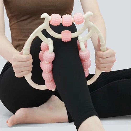 Rouleau de massage à billes rose appliqué sur le mollet, mains de part et d'autre