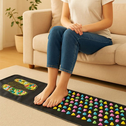 Tapis d'acupression pour les pieds utilisé par une femme assise sur son canapé